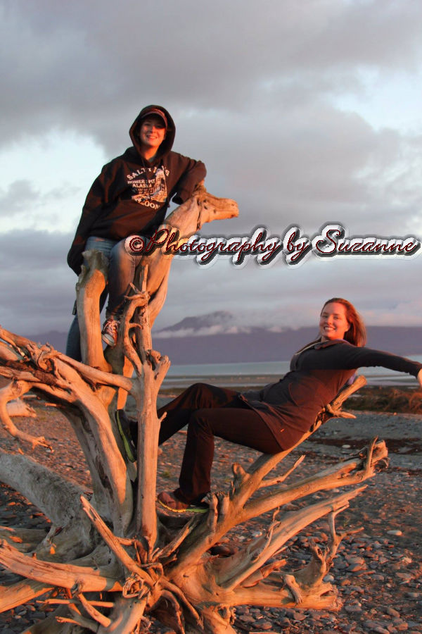 Two women balanced on a large driftwood